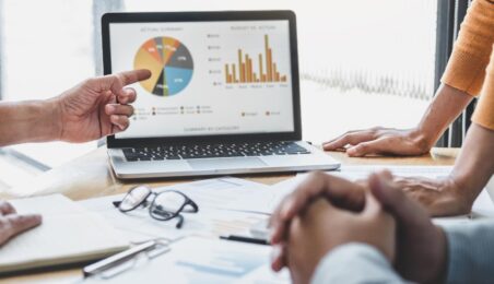 Group of colleagues review a screen of private equity portfolio company metrics