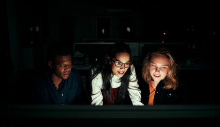 Group of VC colleagues working on computer in dark room